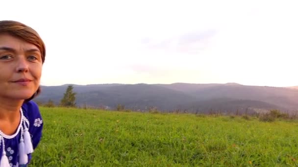 Femme en robe bleue assise au sommet de la montagne et se reposant . — Video