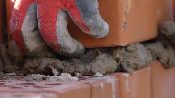 Руки будівельника покладіть цементний розчин. Рука робить кладку цегли . — стокове відео