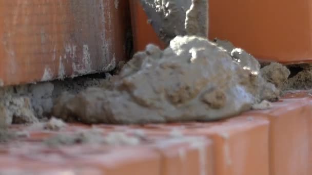 Händerna på byggaren sätta ett cementbruk. Hand gör murverk av tegel. — Stockvideo