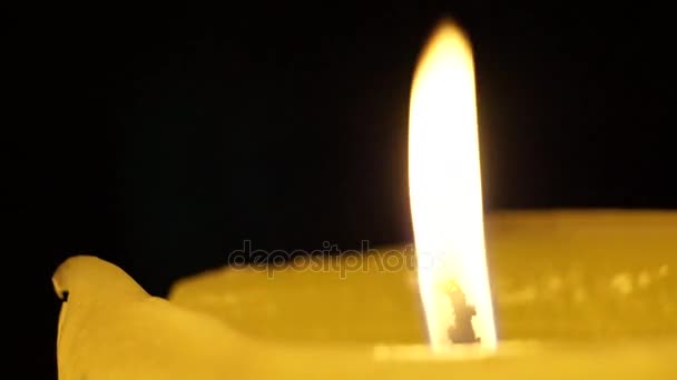 Der Wind löscht die Flamme einer großen Kerze. — Stockvideo