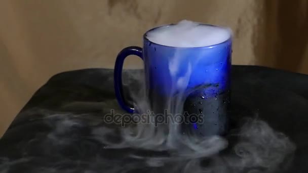 Le verre d'eau avec de la fumée sur la table . — Video