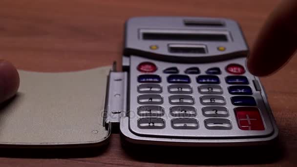 En miniräknare och en Hand att trycka på knappar. — Stockvideo