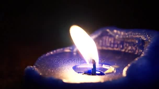 Eine brennende blaue Kerze mit Windstößen. — Stockvideo