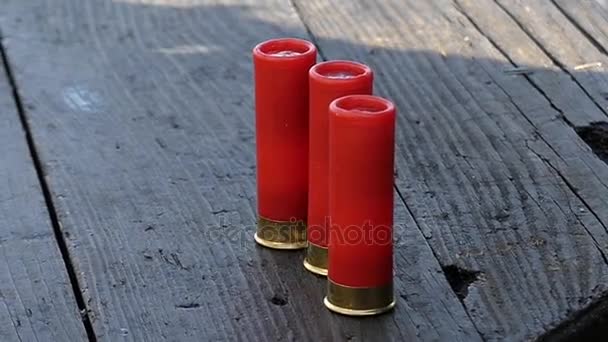 Drie rode Cartridges op een tafel. Handen nemen een van hen. — Stockvideo