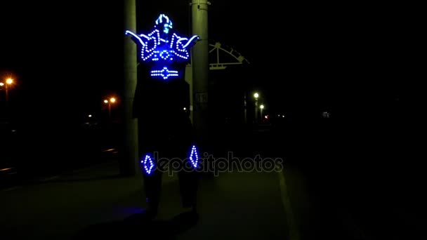 Um palhaço em inclinações dançando em trajes iluminados à noite — Vídeo de Stock