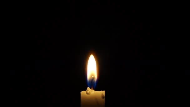 Uma vela de um lit em um fundo preto. Fechar Shot . — Vídeo de Stock