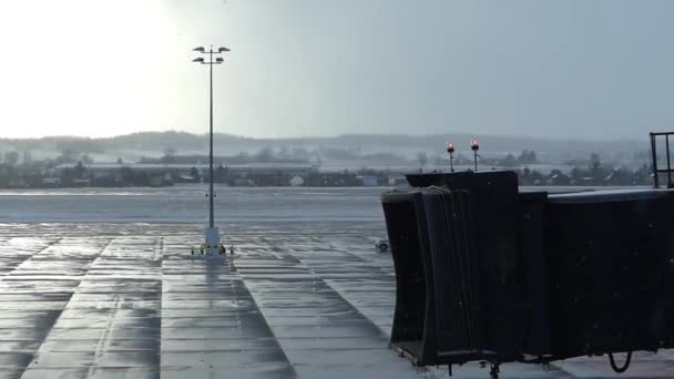 Flugzeug bedeckte schwarze Rampe bei verschneitem Wetter. — Stockvideo