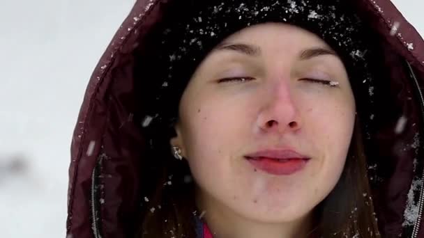 Flocos de neve caindo no rosto da menina em câmera lenta . — Vídeo de Stock