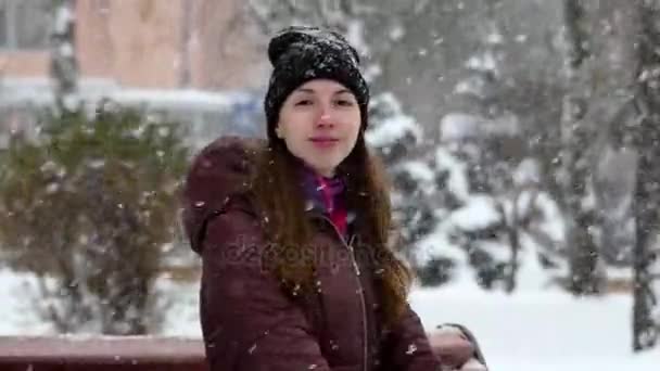 Płatki śniegu spadające na Dziewczyna siedząca w Slo-Mo. — Wideo stockowe