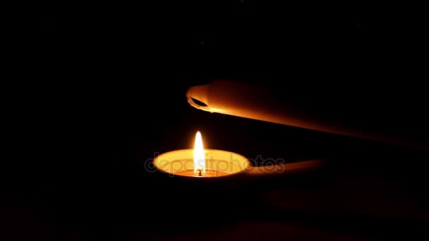 Una candela accesa da una candela votiva con una maniglia di notte . — Video Stock