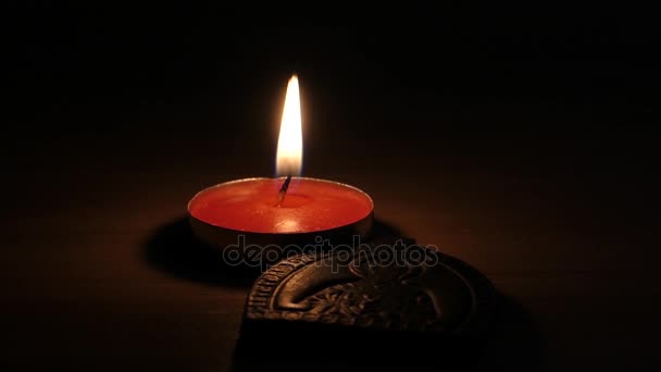 Uma vela votiva de lit que está perto do ícone de madeira de st Mary . — Vídeo de Stock