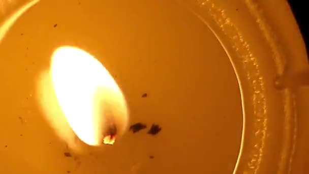 Una candela accesa con cera fusa che viene colpita da una prospettiva angolare superiore — Video Stock
