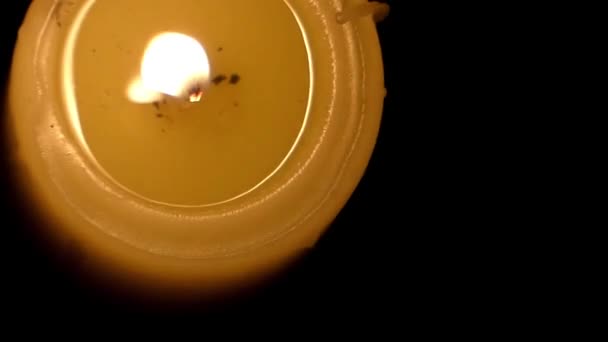 Una vela encendida que llama está brillando desde una perspectiva de arriba abajo . — Vídeos de Stock