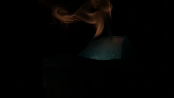 Kouř z modrý kámen Put v hnědé nádoby v noci. — Stock video