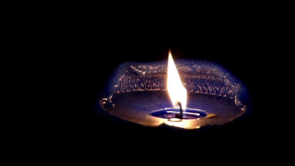 Une belle bougie bleu foncé avec une lumière chatoyante la nuit . — Video