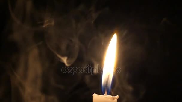 Una vela amarilla con luz brillante y humo misterioso en la noche . — Vídeos de Stock