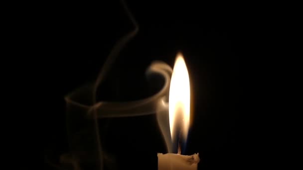 Жёлтое пламя свечи, обнятое загадочным дымом . — стоковое видео