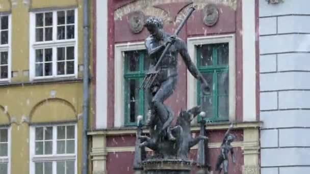 Un monumento de bronce de Neptuno con un tridente frente a un monumento europeo del siglo Xviii en una tormenta de nieve de invierno — Vídeos de Stock