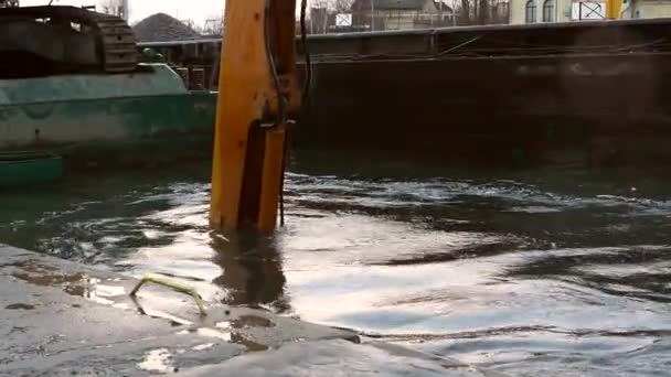 Egy hatalmas kotrógép gombóc mozog-e fel a egy víz tó a város — Stock videók