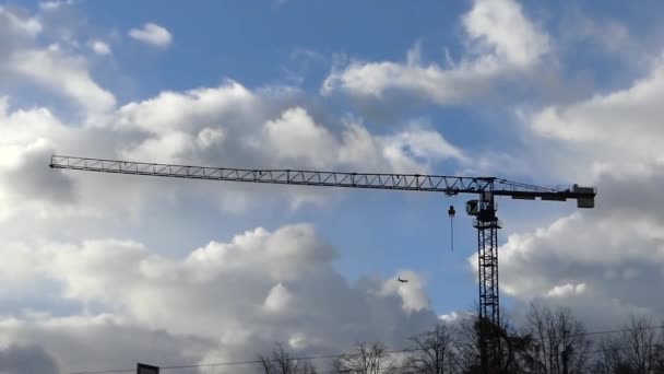 A Huge Tower Crane Standing in the Beautiful Nature Background and a Flying Airplane. — Stock Video