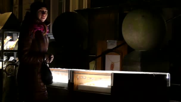Улыбающаяся девушка смотрит на магазин окон с двумя светящимися стендами и глобусом осенью . — стоковое видео