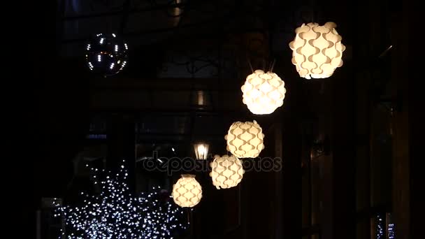 Lampade a sfera sospese e ondeggianti nella strada buia che illuminavano nella notte . — Video Stock