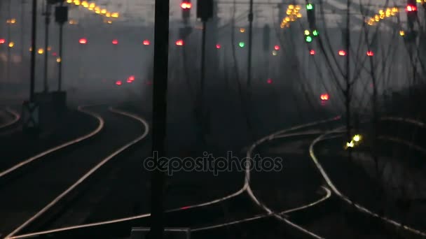 Train en métal impressionnant se déplaçant le long des chemins de fer courbes avec beaucoup de feux de circulation lumineux la nuit en Europe de l'Est à l'automne — Video