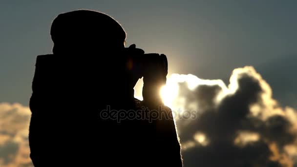 Впечатляющий закат снимает красивая женщина с профессиональной камерой, стоящей в профиле в начале весны — стоковое видео