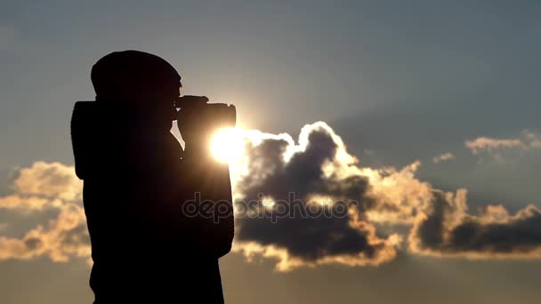 Západ slunce je zastřelen krásná žena s profesionální fotoaparát stojící v profilu v brzy na jaře — Stock video