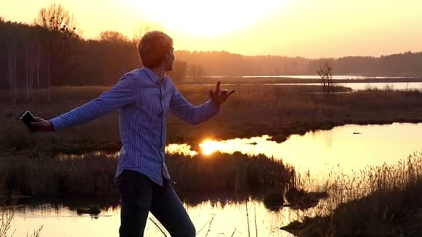Energetic Young Man is Dancing With Earbuds in Ears Latin Dance in Slow Motion at Sunset. — Stock Video