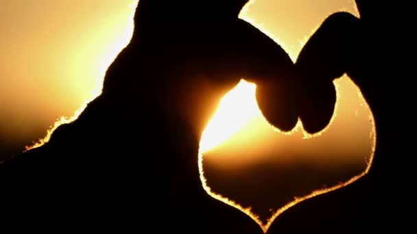 Young Woman is Smiling and Keeping a Love Sign With Two Hands at Sunset Outdoors in Early Spring — Stock Video