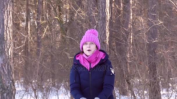 Mulher incrível está pegando e jogando neve para cima e levantando suas mãos na floresta nevada em movimento lento — Vídeo de Stock