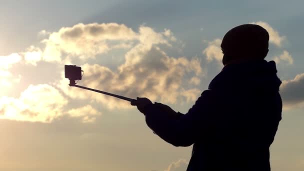 Schön aussehende Frau zeigt Daumen hoch Geste und macht ein Selfie-Foto während eines beeindruckenden Sonnenuntergangs im frühen Frühling — Stockvideo