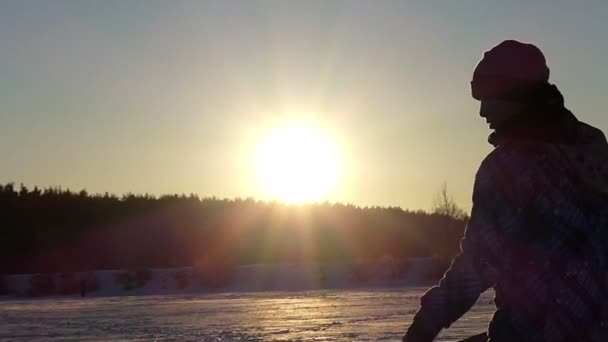 Little Boy Attack bola de neve com espada de madeira em movimento lento ao pôr do sol . — Vídeo de Stock