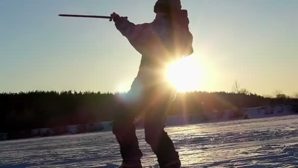 Niño pequeño en invierno jugando con la sombra con la espada de madera al atardecer en cámara lenta . — Vídeos de Stock