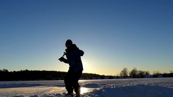 Jongetje vieren een kleine overwinning en springen in de hemel met de beker in de Hand in Slow Motion bij zonsondergang. — Stockvideo