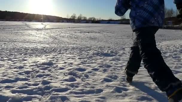 Ragazzo che corre e salta nella neve al rallentatore . — Video Stock