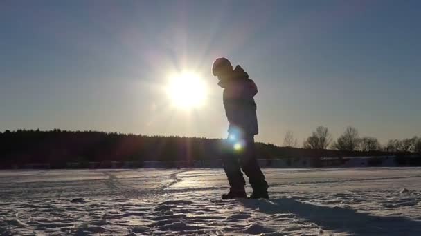 Fun стрибок і падіння вниз хлопчика на заході сонця в повільному темпі. Сніг погода. — стокове відео
