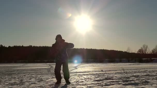 Маленький мальчик прыгает в небо на закате в медленном движении в зимний сезон . — стоковое видео