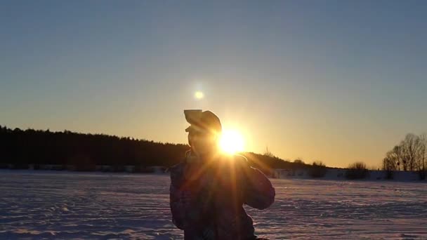 Mały chłopiec wznoszą się złoty kielich w zwolnionym tempie o zachodzie słońca. — Wideo stockowe