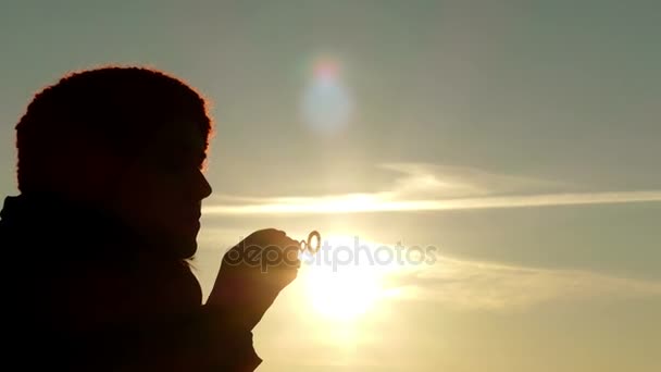 Flicka på Sunset blåsa bubblor i 4 k-Video. — Stockvideo