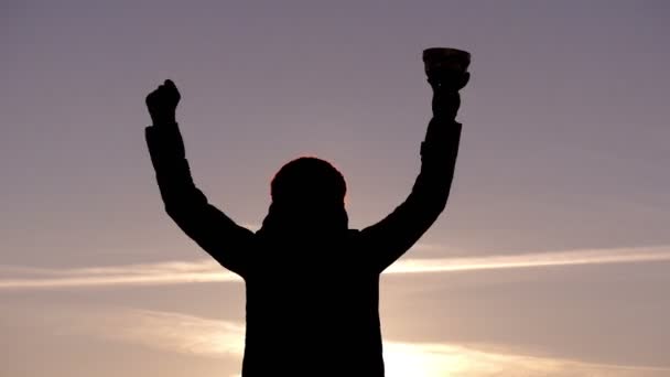 女孩庆祝她的胜利上升金杯在夕阳埋头在 4 k 视频. — 图库视频影像