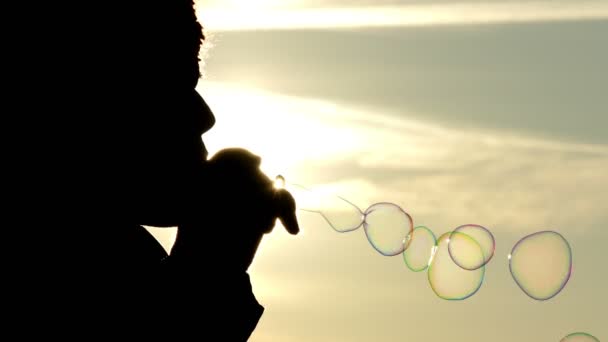 Žena v chladné období foukat bubliny při západu slunce v 4 k videa. — Stock video