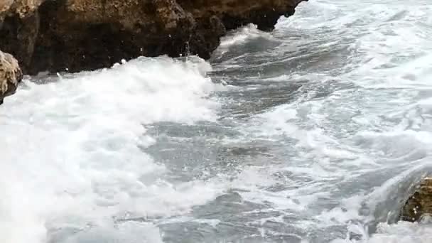 Schizzi schiumosi di onde ondulate sulla spiaggia del Mar Rosso con grandi pietre al rallentatore . — Video Stock