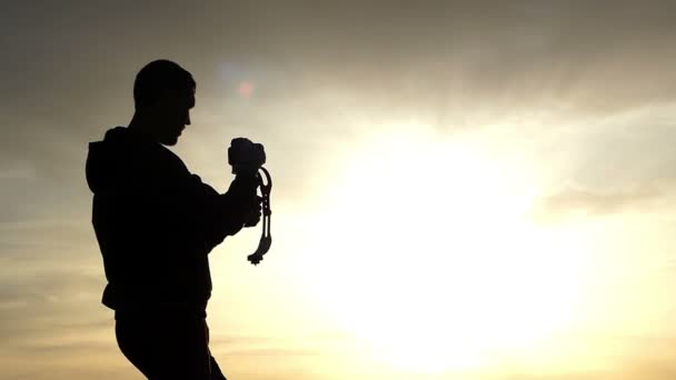 Cinema por do sol - homem com Steady Cam fazendo vídeo. — Vídeo de Stock