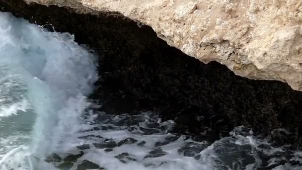 Пена всплески приливных волн на пляже Красного моря с большими камнями в солнечный день осенью — стоковое видео