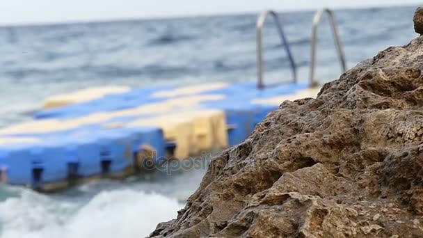 Παραλία σε αργή κίνηση - πλαστικό Pontoon εκτός εστίασης που λικνίζονται στα κύματα της θάλασσας. — Αρχείο Βίντεο