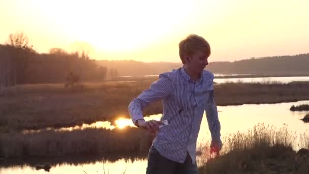 Active Young Man sta praticando alcuni balli da sala e sta alzando le mani a turno con uno splendido tramonto sullo sfondo . — Video Stock