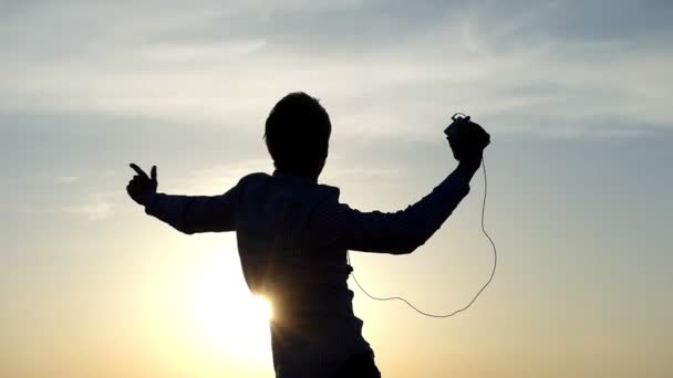 Impressionante pôr do sol e uma dança energética de um jovem no banco de um lago florestal no início da primavera — Vídeo de Stock