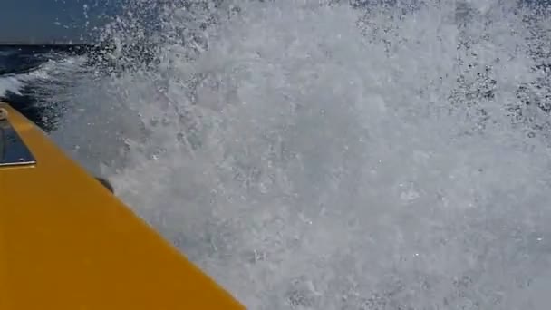 Μονοπάτι αφρός στην επιφάνεια του νερού κοντά σε ένα ραγδαία εξελισσόμενο μηχανοκίνητο σκάφος σε αργή κίνηση — Αρχείο Βίντεο